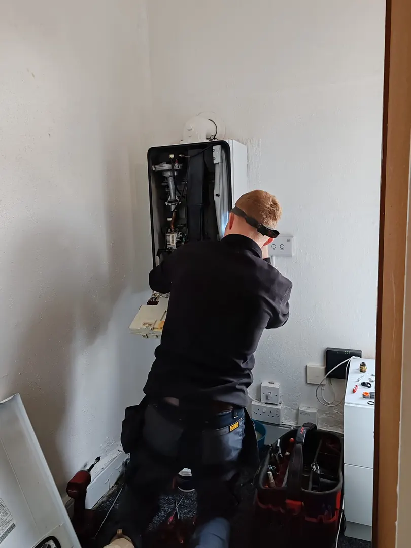 Heating engineer working on a wall-mounted boiler in Bridgend
